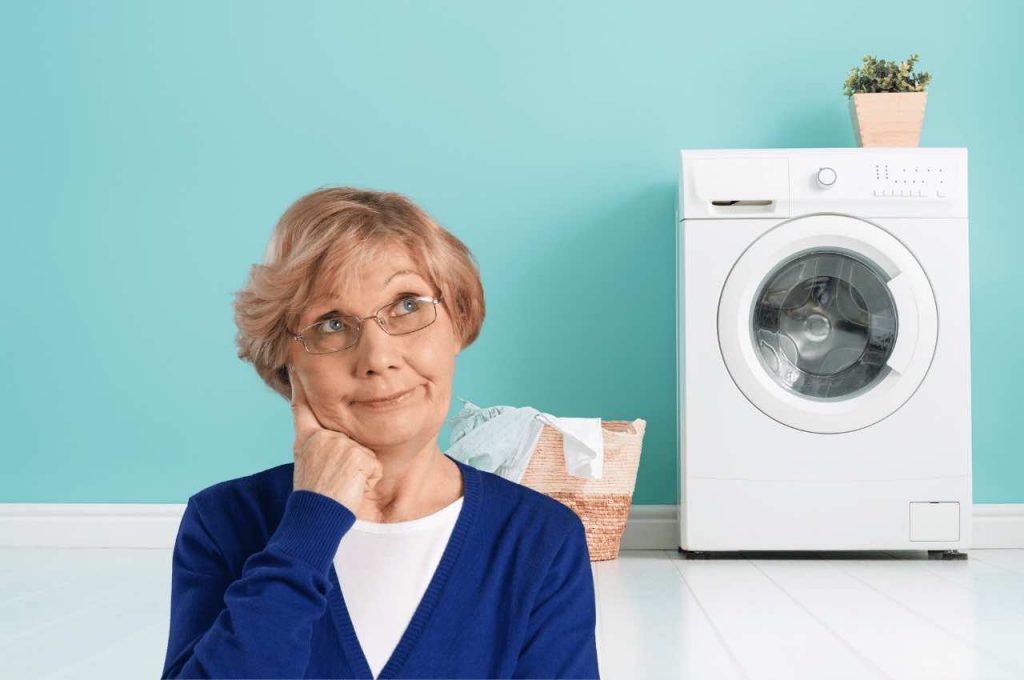 Nonna, con alle spalle il cesto del bucato e la lavatrice