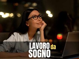 Ragazza seduta alla scrivania e al pc, con sguardo sognante
