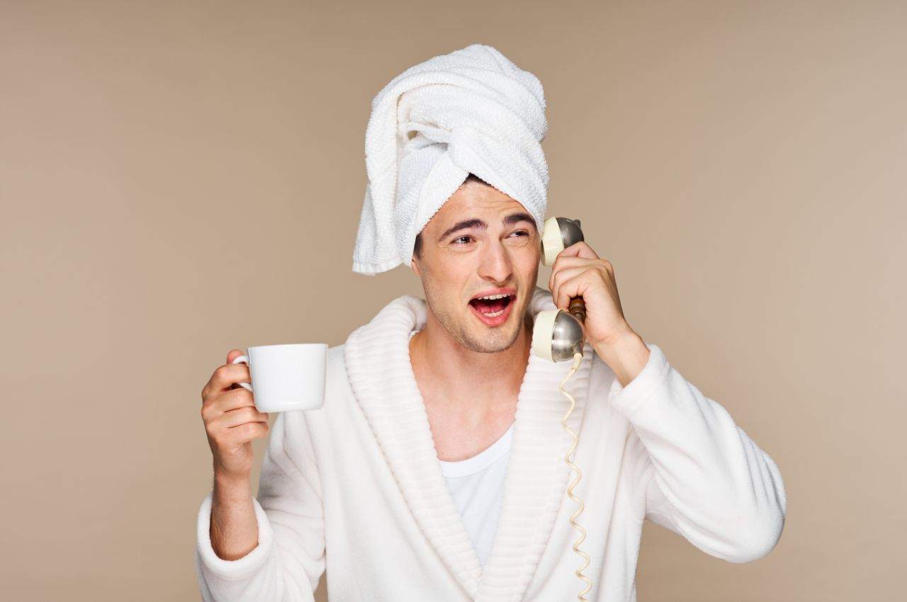 uomo con tazza e telefono in mano intento a fare un pettegolezzo