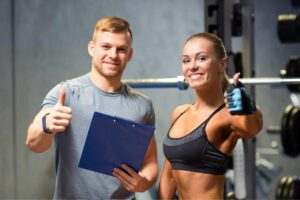 coach e ragazza che si allena con il pollice in su e sorridenti come simbolo delle migliori app per sport